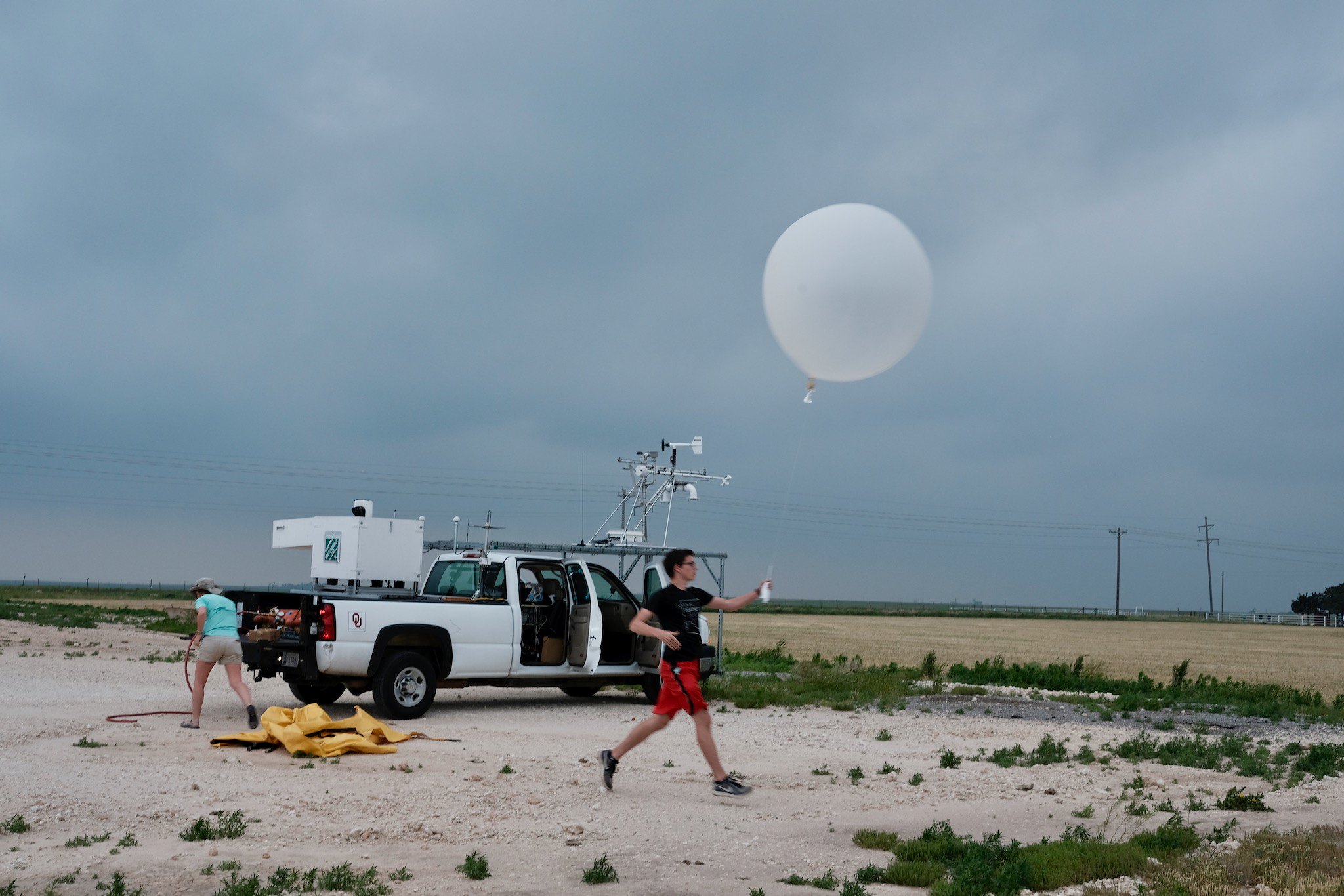 OU CIMMS Research Associate and student Nolan Meister releases a weather balloon with instruments attached to measure aspects of the upper atmosphere. (Photo by Mike Coniglio/NOAA NSSL) 