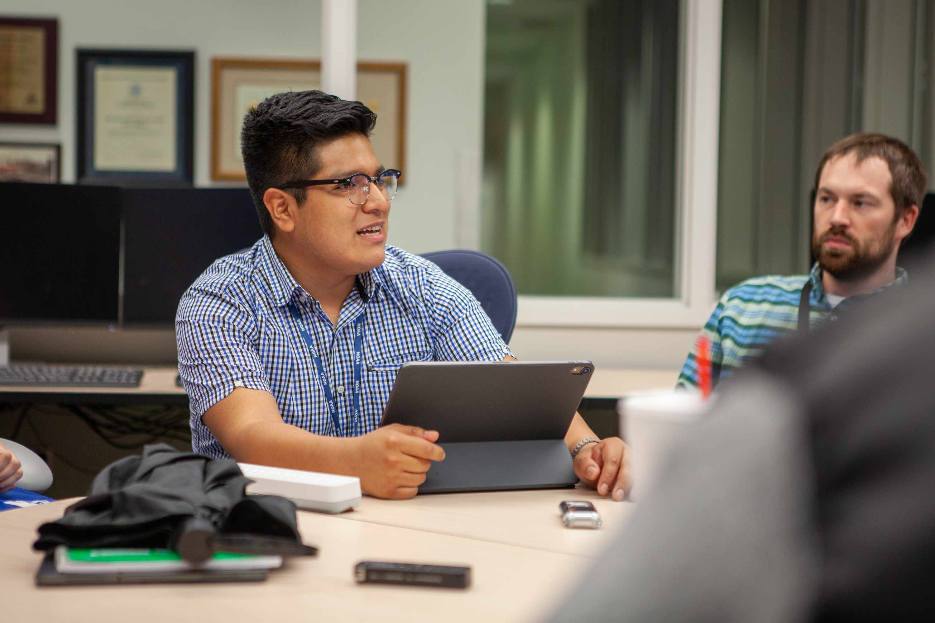 A Person sitting at a table with a computer in front of them.