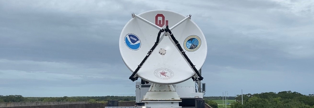 A weather radar on the back of a truck, poised and ready to collect data.